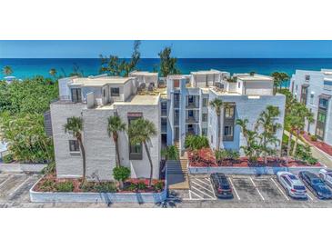 Oceanfront condo building with ample parking and lush landscaping at 2950 N Beach Rd # A315, Englewood, FL 34223