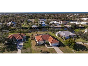 An aerial view of a Florida waterfront home with tile roof, pool, and lush landscaping at 4658 Arlington Dr, Placida, FL 33946