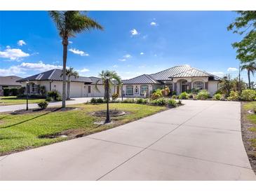 Beautiful single-story home with a concrete driveway, manicured lawn and landscaping, and metal roof at 646 Boundary Blvd, Rotonda West, FL 33947