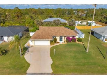 Single-Gathering home with a large front yard and a two-car garage, seen from an aerial perspective at 9266 Carnation Ave, Englewood, FL 34224