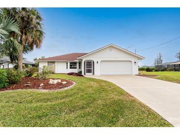 Single-story home with a red tile roof, white walls, and a landscaped front yard at 119 Bunker Rd, Rotonda West, FL 33947