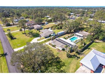 Sprawling property featuring a sparkling pool, RV parking, and lush landscaping, nestled in a tranquil neighborhood at 5868 Denison Dr, Venice, FL 34293