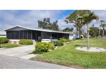 Charming single-story home featuring a screened porch, carport, and well-maintained landscaping at 735 Summersea Ct, Englewood, FL 34223