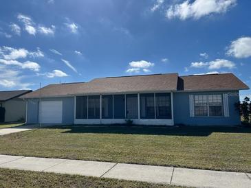 Charming single-story home with a well-maintained lawn and a screened front porch, perfect for enjoying outdoor living at 13537 Bennett Dr, Port Charlotte, FL 33981
