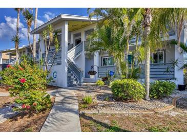 Inviting two-story home with a well-maintained walkway, landscaped yard, and charming tropical foliage at 6800 Placida Rd # 235, Englewood, FL 34224