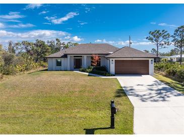 Lovely single-story home with a well-kept lawn, a two-car garage, and a simple front garden at 7442 Clearwater St, Englewood, FL 34224