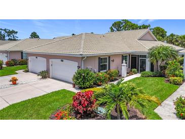 Charming villa with a well-manicured lawn, colorful flowerbeds, and a two-car garage at 1577 Monarch Dr # 1577, Venice, FL 34293