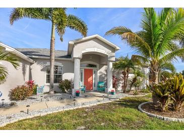 Charming home featuring a welcoming front entrance and beautifully landscaped yard at 13354 Blytheville Ave, Port Charlotte, FL 33981