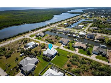 Waterfront home with lush landscaping, screened pool, and canal access at 15691 Meacham Cir, Port Charlotte, FL 33981