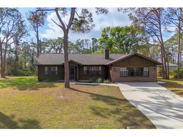 Charming single-story home with a brick facade and a well-maintained front lawn at 3892 Alwood St, North Port, FL 34291