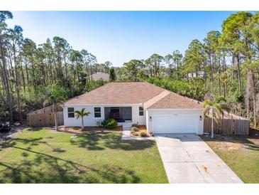 Charming single-story home with a well-manicured lawn, inviting entrance, and attached two car garage at 14795 San Domingo Blvd, Port Charlotte, FL 33981