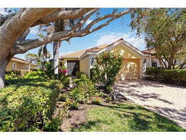 Charming home with a terracotta roof, well-manicured landscaping, and a brick driveway at 10508 Crooked Creek Dr, Venice, FL 34293
