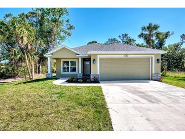Charming single-story home featuring a two-car garage, landscaped front yard, and a welcoming facade at 1183 Cedar Ave, Englewood, FL 34223