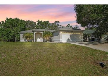 Charming single-story home featuring a well-maintained lawn and attached two car garage at 2495 De Garmo St, North Port, FL 34291