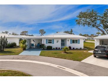 Charming single-story home featuring a well-manicured lawn and bright blue accents on the shutters at 414 Circlewood Dr # H2, Venice, FL 34293