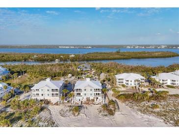 Aerial view showcases pristine beach houses and lush waterways, offering a serene coastal living experience at 7430 Palm Island Dr # 3813, Placida, FL 33946