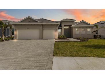 Beautiful single-story home with a three car garage and a well manicured lawn at 8562 Shore Lake Dr, Englewood, FL 34224