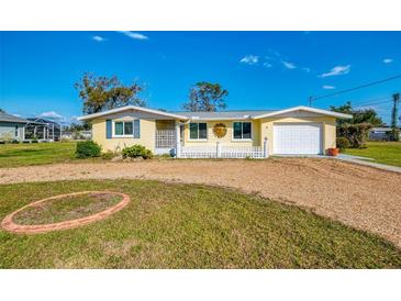 Charming single-story home with a gravel driveway and a well-maintained front lawn at 91 Beverly Cir, Englewood, FL 34223