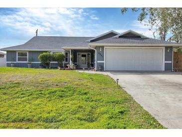 Charming single Gathering home featuring an attached garage and well-manicured lawn at 9341 Oceanspray Blvd, Englewood, FL 34224