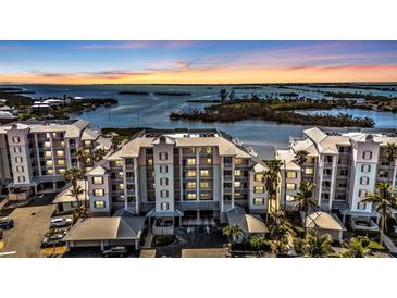 Beautiful condominium complex featuring multi-story buildings and scenic waterfront views at sunset at 13313 Gasparilla Rd # 404, Placida, FL 33946
