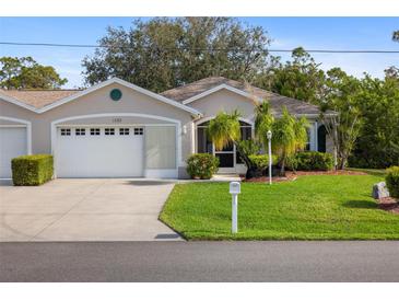 Charming single-story home with well-manicured lawn and attached two car garage at 1332 Hedgewood Cir, North Port, FL 34288