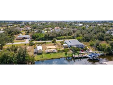 Aerial view showcasing home with waterfront access, private dock, boat, and outdoor entertaining at 14382 Lillian Cir, Port Charlotte, FL 33981