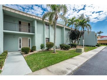 Inviting condominium featuring a well-manicured lawn with several palm trees at 1461 Aqui Esta Dr # B3, Punta Gorda, FL 33950
