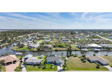 Beautiful community of waterfront homes with boat docks and scenic canal access under a sunny blue sky at 15652 Ruston Cir, Port Charlotte, FL 33981