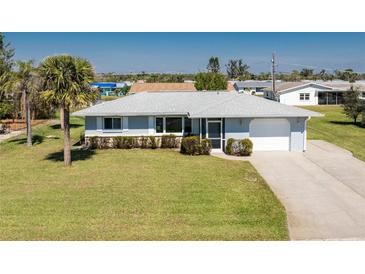 Charming single-story home with a manicured lawn, and an attached one car garage at 1720 Florence Ave, Englewood, FL 34223