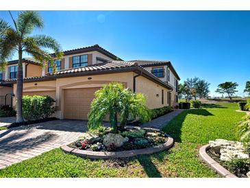 Charming two-story townhome with a tile roof, attached garage, and lush landscaping at 20110 Ragazza Cir # 102, Venice, FL 34293