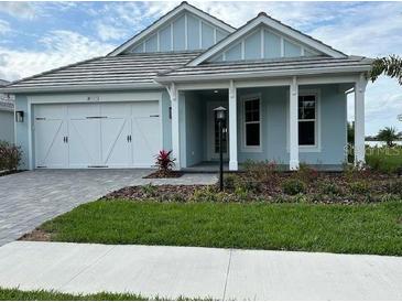 Charming single Gathering home features a two car garage, neutral paint, and manicured lawn at 8375 E Windbound Ct Ct, Sarasota, FL 34240