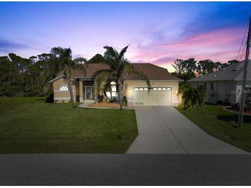 Charming single-story home with a well-manicured lawn and two-car garage, framed by mature palm trees at dusk at 127 White Marsh Ln, Rotonda West, FL 33947