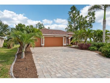 Charming single-story home featuring a paver driveway, lush landscaping, and a welcoming two-car garage at 16137 Alcira Cir, Punta Gorda, FL 33955