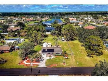 Expansive property featuring a charming home, lush landscaping, and neighborhood pond views at 840 E 7Th St, Englewood, FL 34223