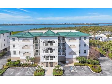 Stunning building exterior with a green roof, balconies, and lush landscaping overlooking the water at 9203 Griggs Rd # 204, Englewood, FL 34224