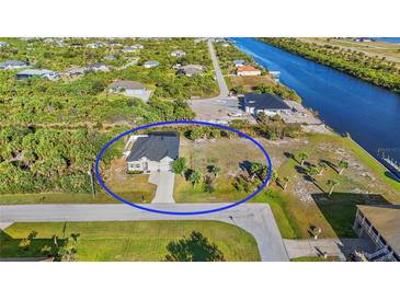 Gorgeous aerial view of home and property showcasing the neighborhood canal in the backyard at 10498 Bay State Dr, Port Charlotte, FL 33981