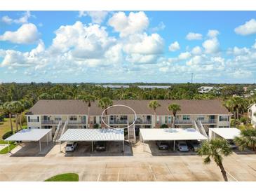 Beautiful condo building with covered parking and lush landscaping at 202 Silver Lake Dr # 203, Venice, FL 34292