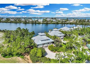 Stunning aerial view of waterfront homes with lush landscaping and beautiful waterfront access at 38 Seawatch Lake Dr, Boca Grande, FL 33921