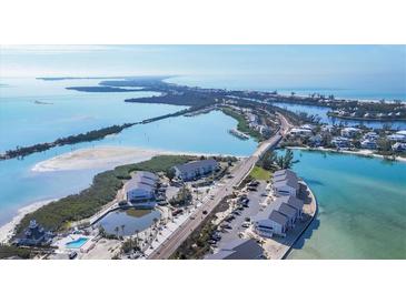 Stunning aerial view showcases beachfront condos near a serene pool and expansive ocean views at 6000 Boca Grande Cswy # D38, Boca Grande, FL 33921