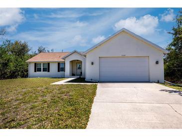 Charming single-story home with a two-car garage, well-manicured lawn, and inviting curb appeal at 6368 Pennell St, Englewood, FL 34224