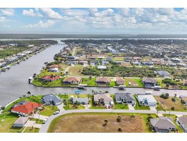 Gorgeous aerial view of waterfront homes in a coastal community with lush greenery and deep canals at 9382 Rosebud Cir, Port Charlotte, FL 33981
