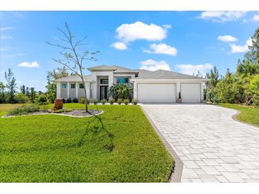 Stunning single-Gathering home with a well-manicured lawn and a paved driveway leading to a three-car garage at 10491 Sarasota Rd, Port Charlotte, FL 33981