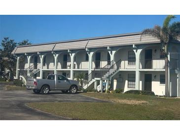 Multi-Gathering home with a tile roof, arches, staircases, and a silver truck in the driveway at 150 Englewood Isles Pkwy # 201, Englewood, FL 34223