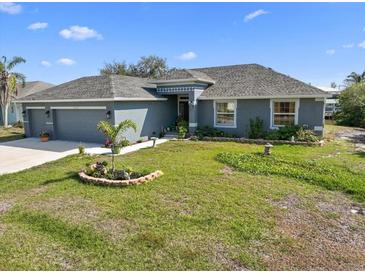 Charming single-story home featuring a well-manicured lawn and a two-car garage at 15251 Appleton Blvd, Port Charlotte, FL 33981