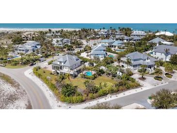 Beautiful aerial view of coastal homes with lush tropical landscaping near white sandy beaches and blue water at 16251 Sunset Pines Cir, Boca Grande, FL 33921