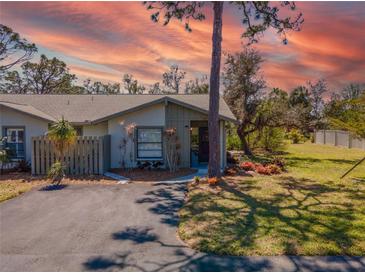 Charming one-story home featuring a well-manicured lawn and a paved driveway against a vibrant sunset backdrop at 107 Jose Gaspar Dr, Englewood, FL 34223