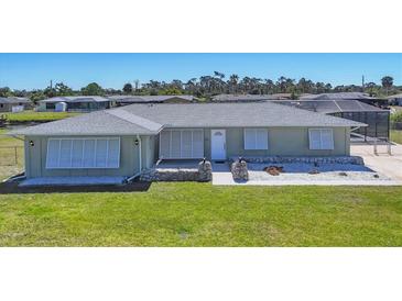 Charming single-story home with well-maintained lawn and stone-accented landscaping at 13 Caddy Rd, Rotonda West, FL 33947