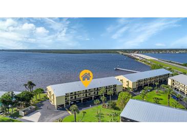 Waterfront condos featuring boat docks, lush lawns, and nearby bridge access at 14459 River Beach Dr # 129, Port Charlotte, FL 33953