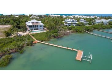 Stunning waterfront property featuring a private dock, pool, and lush landscaping at 19 Grouper Hole Dr, Boca Grande, FL 33921