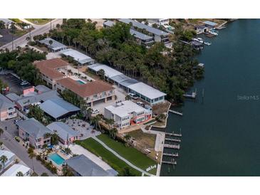 Stunning aerial view of waterfront property with docks, lush greenery, and community amenities at 2405 N Beach Rd # 10, Englewood, FL 34223